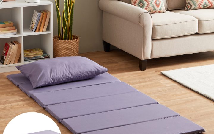 Foldable tri-fold guest mattress opened beside a sofa