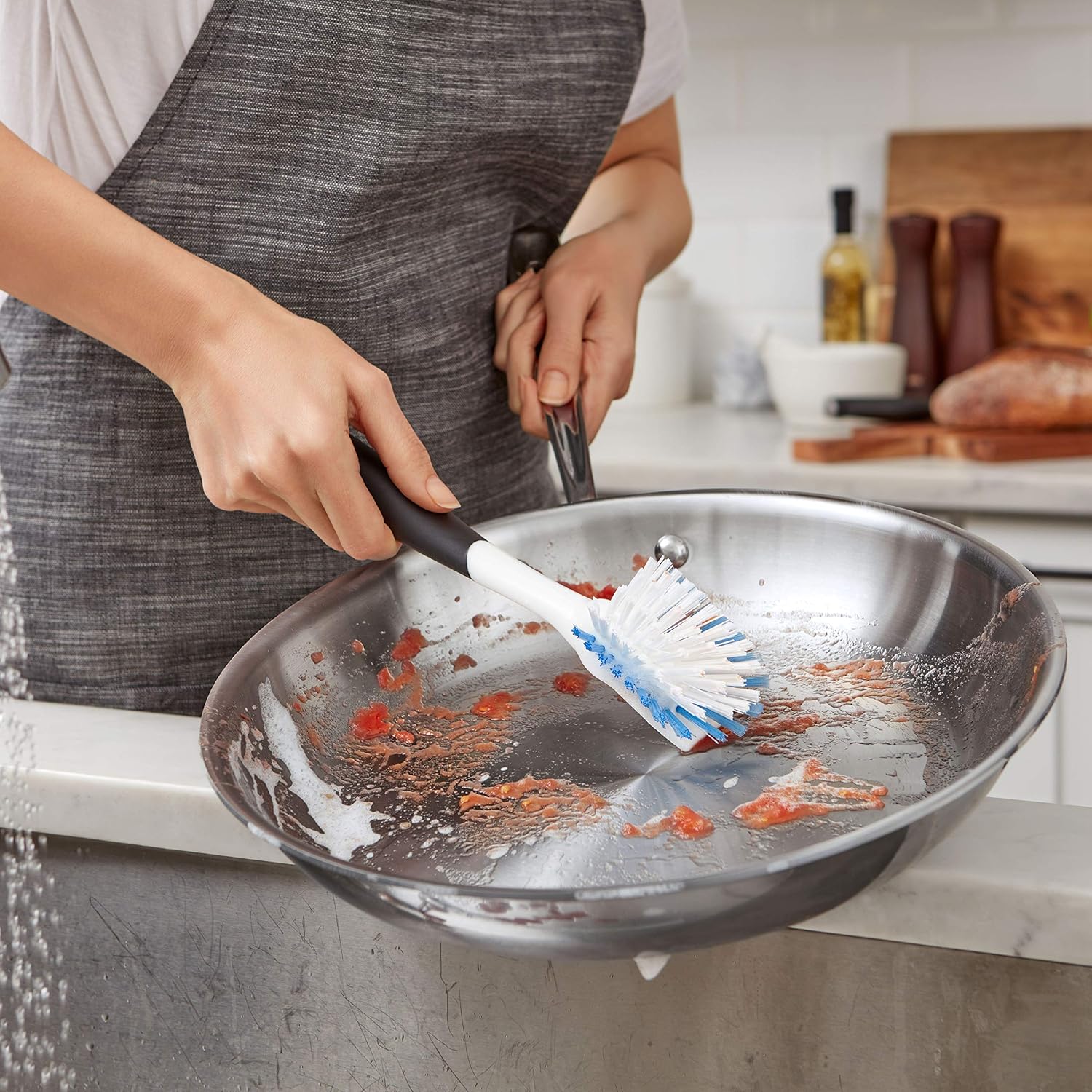 OXO listing photograph showing its dish brush cleaning a pan
