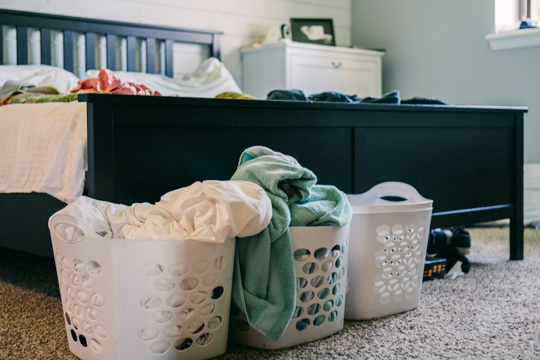 Baskets of clothes at the foot of a bed, showing how clean and dirty laundry can pile up in a family home