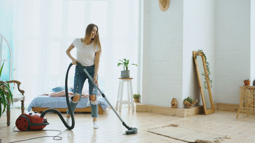 Person vacuuming a home floor, illustrating a realistic weekly floor-cleaning cadence