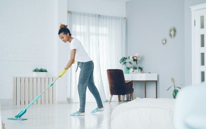 Person mopping the floor in a home, illustrating a realistic weekly cleaning routine