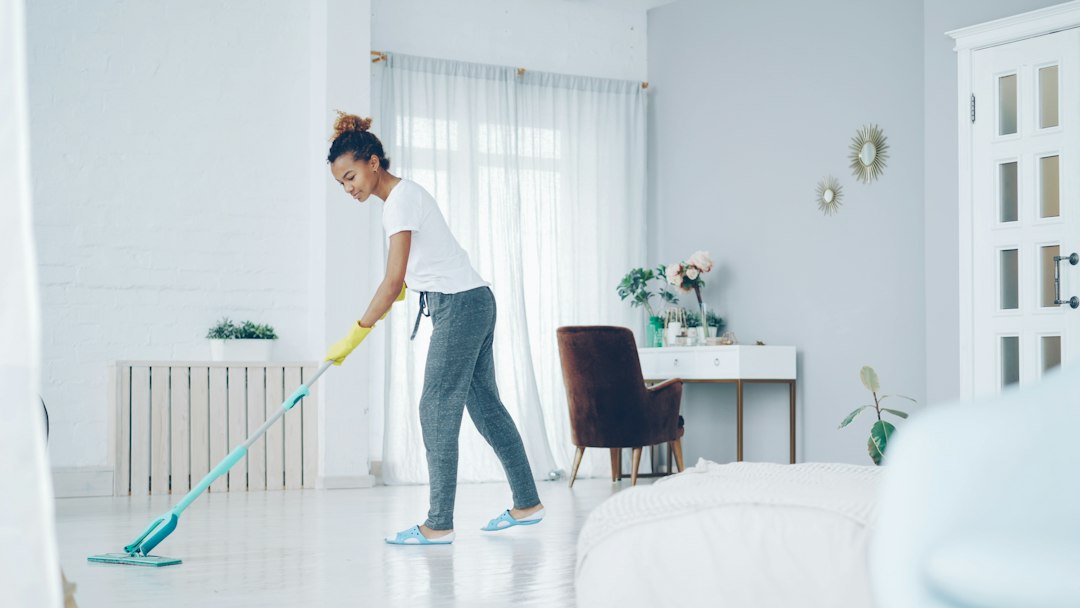 Person mopping the floor in a home, illustrating a realistic weekly cleaning routine