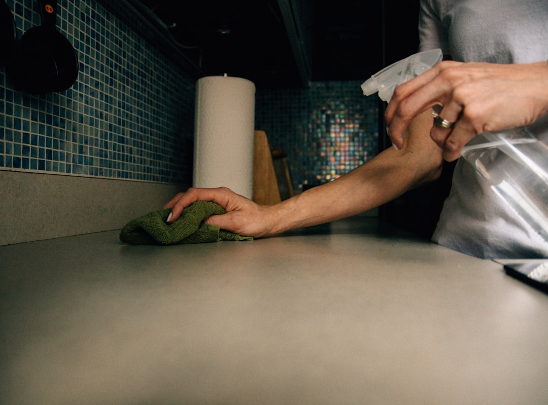 Hands wiping a kitchen surface with a cloth during a quick evening cleanup