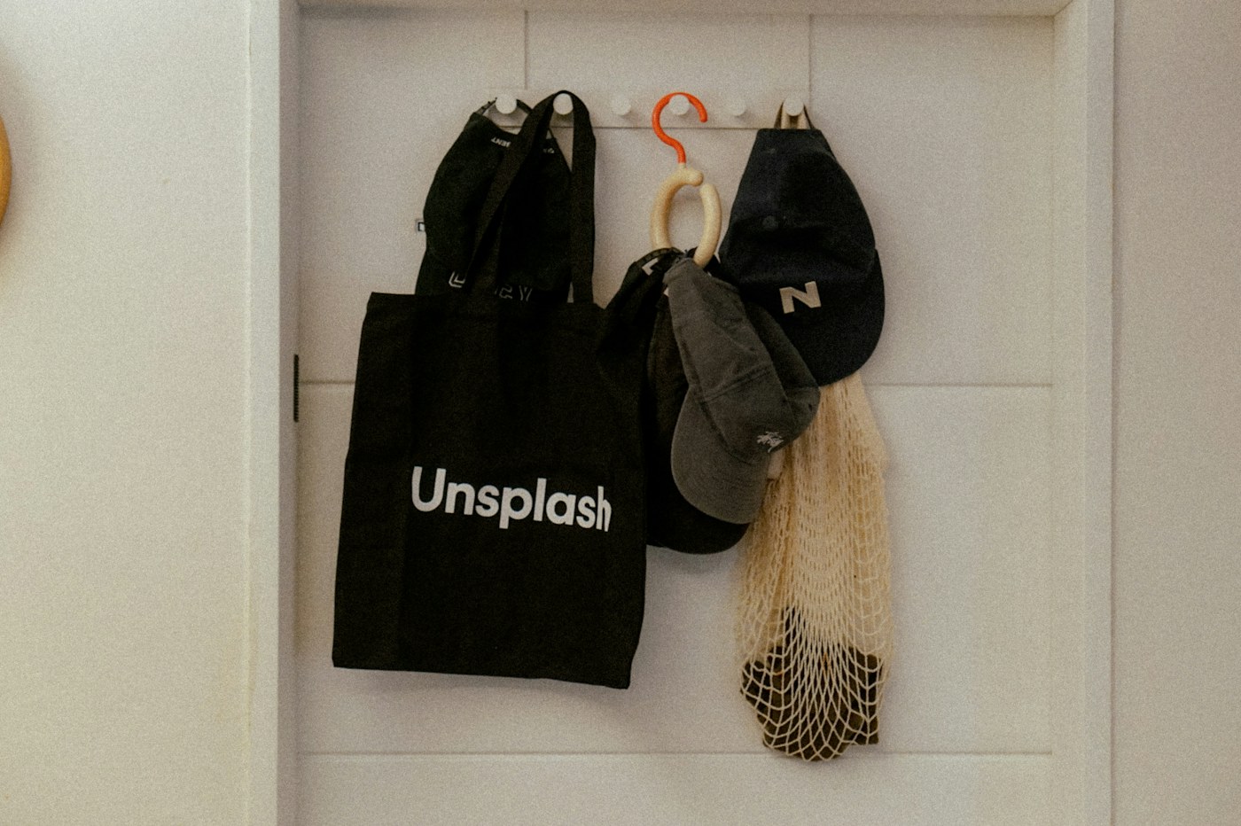 Daily-use bags stored on wall hooks as a compact launch system