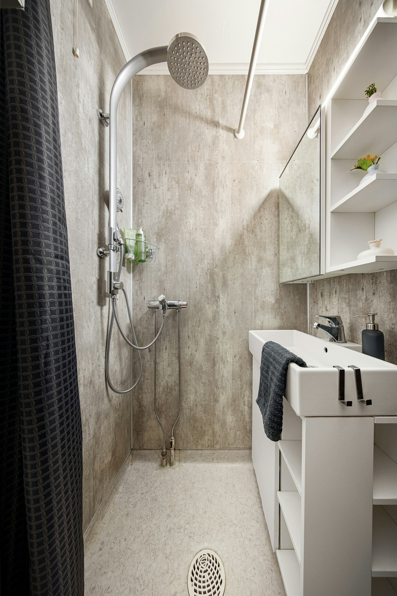 Compact bathroom with shower and wall shelving
