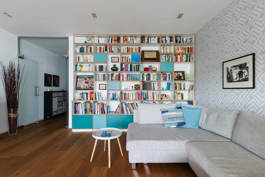 Wall bookcase with books and closed storage in a living room