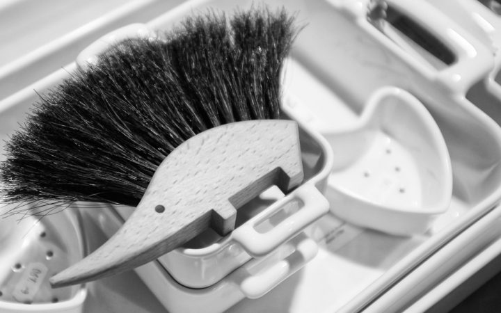 Household cleaning brush stored vertically in a small container