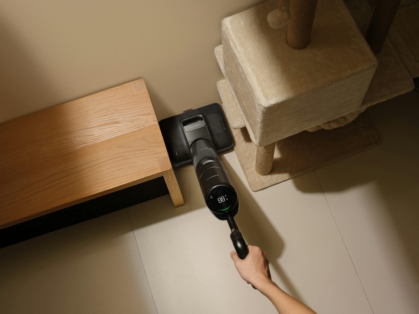 Person vacuuming a corner with a cordless vacuum