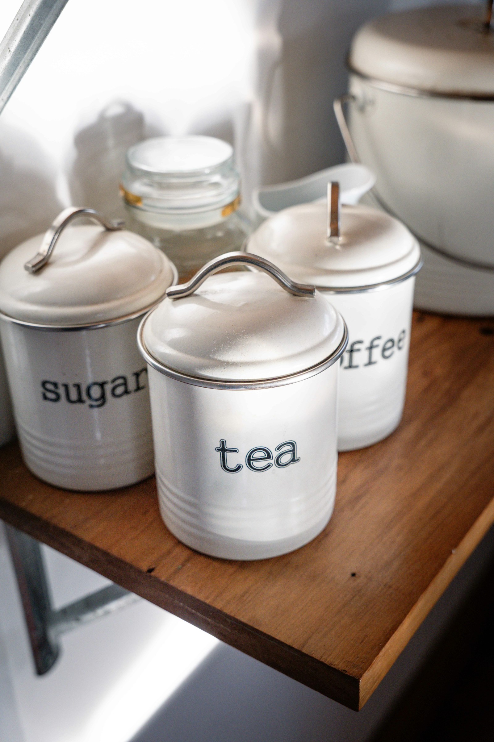 White kitchen canisters labeled tea, sugar, and coffee