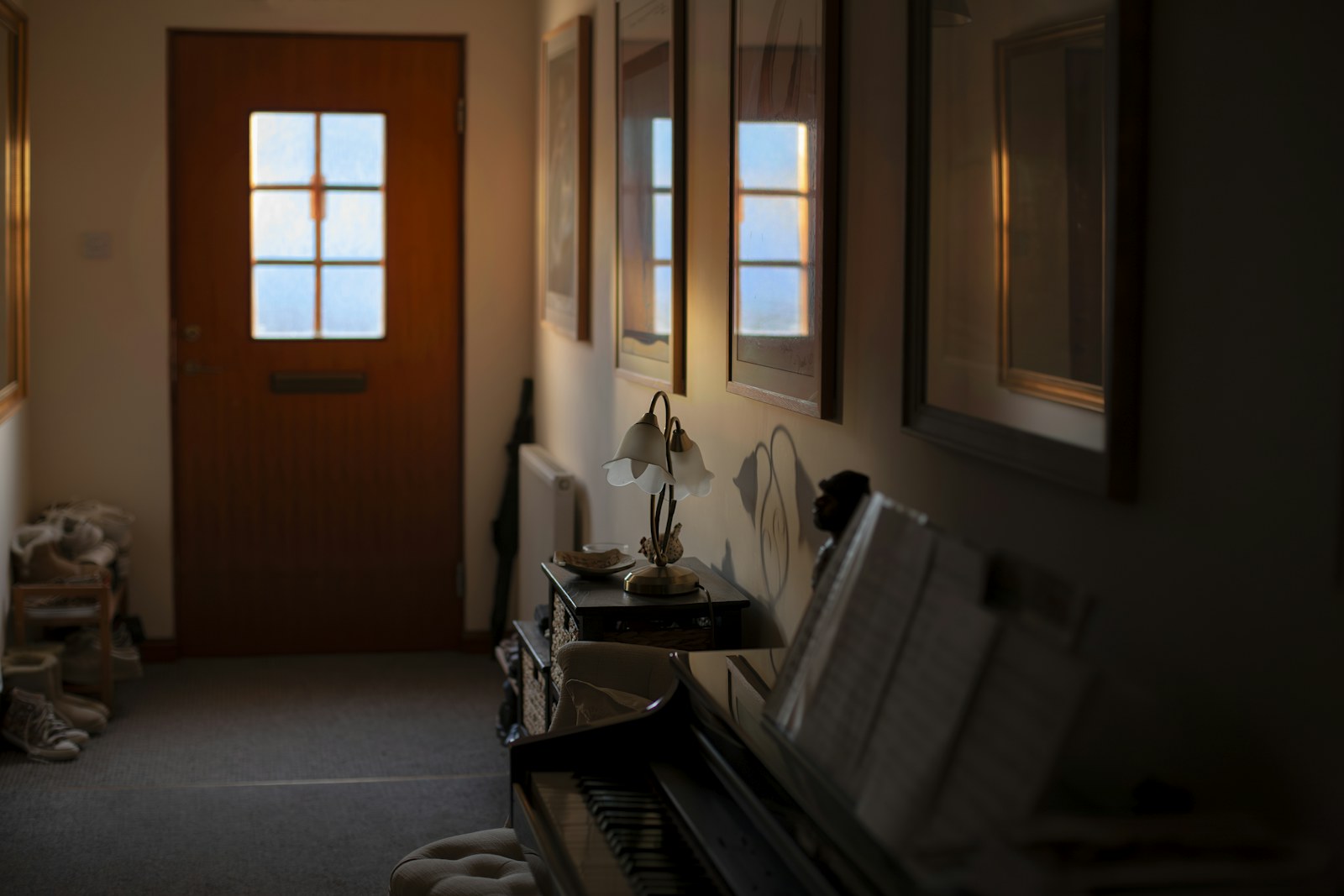 Hallway with a door, piano, and artwork