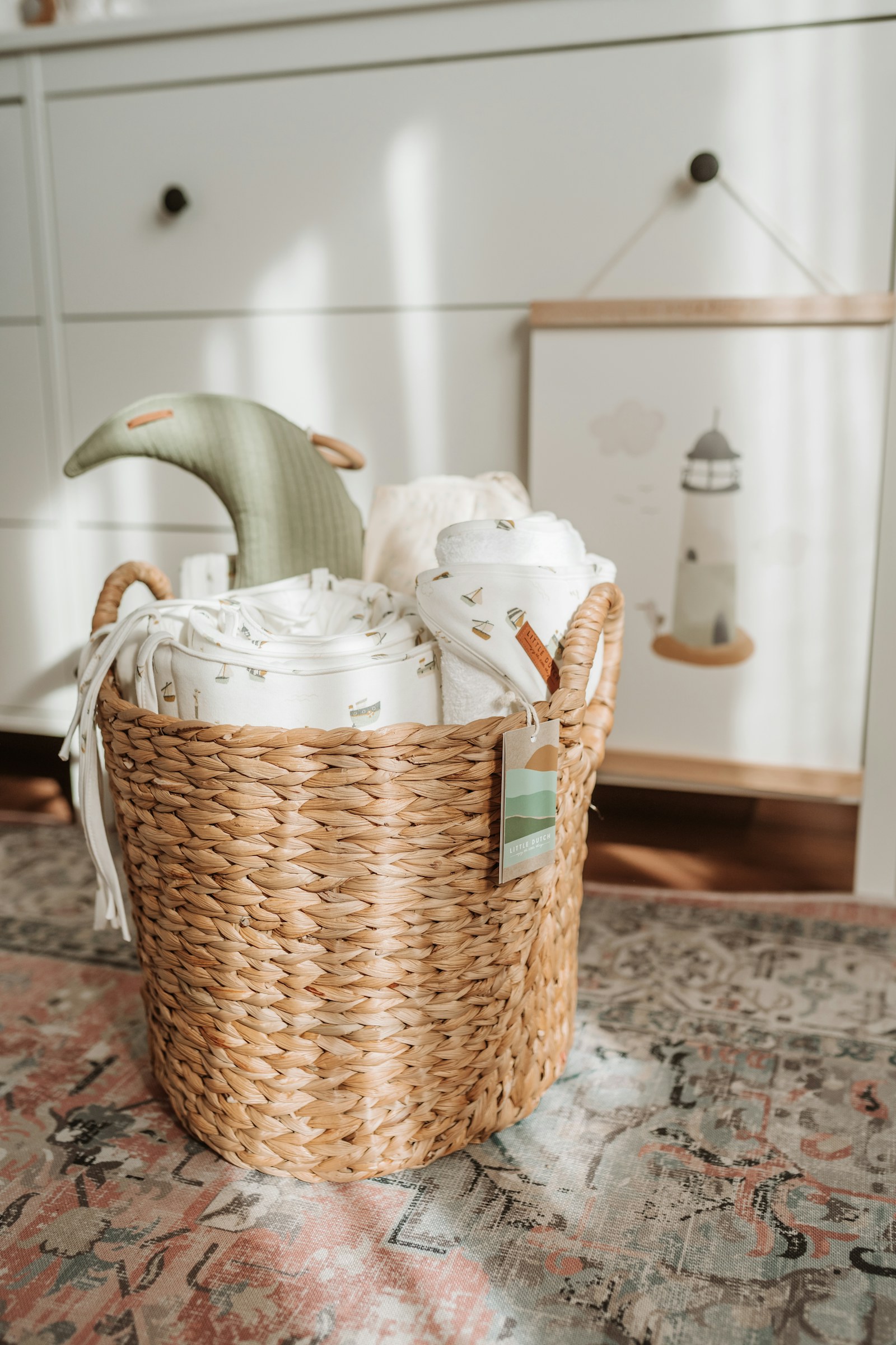 a wicker basket filled with blankets on top of a rug