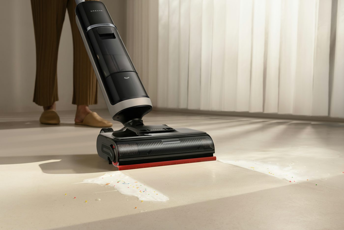 A person using a cordless vacuum cleaner on a floor