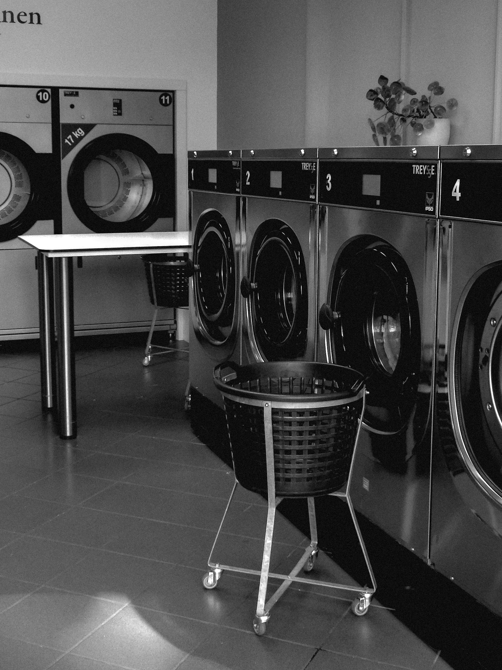 Row of washing machines with laundry baskets