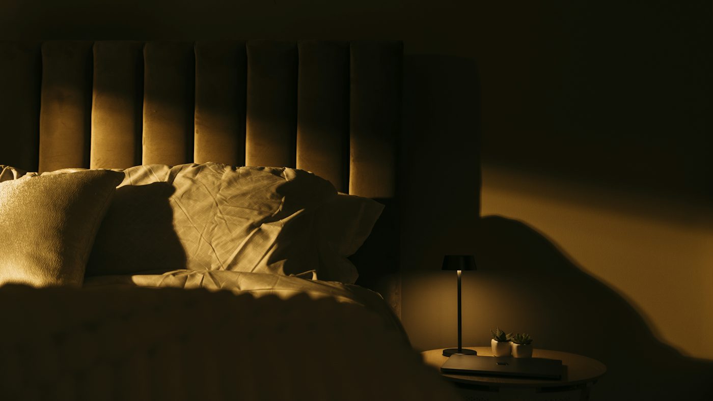 a bedroom with a bed and a night stand