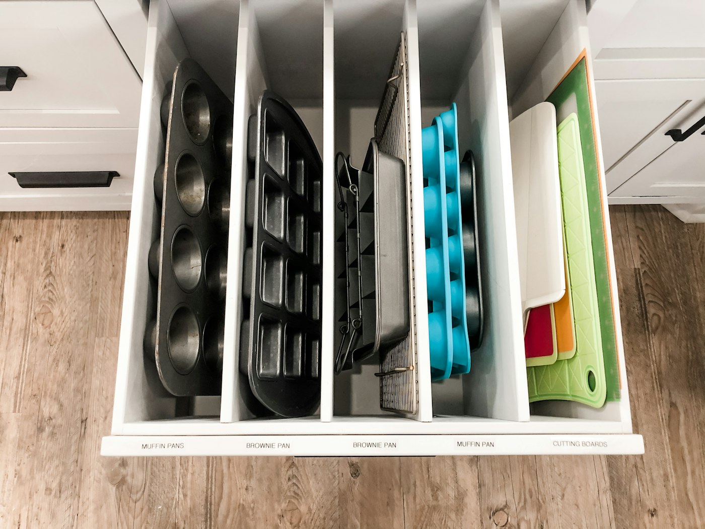 Kitchen drawer with vertical dividers showing a simple space-efficient storage approach