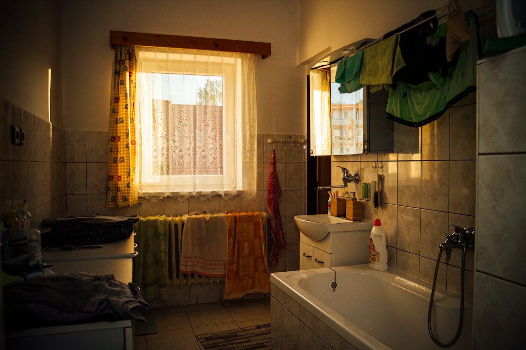 Everyday bathroom with towels and clothing showing the storage pressure of shared use