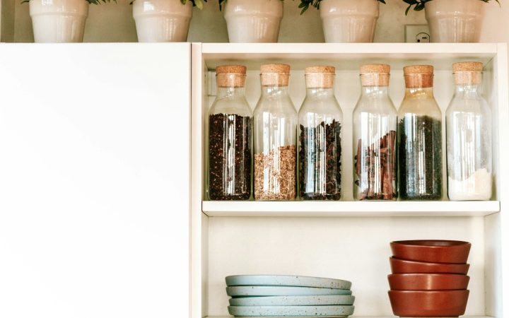 a kitchen shelf filled with dishes and plants