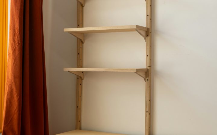 Light wood shelving unit and cabinet with an open drawer
