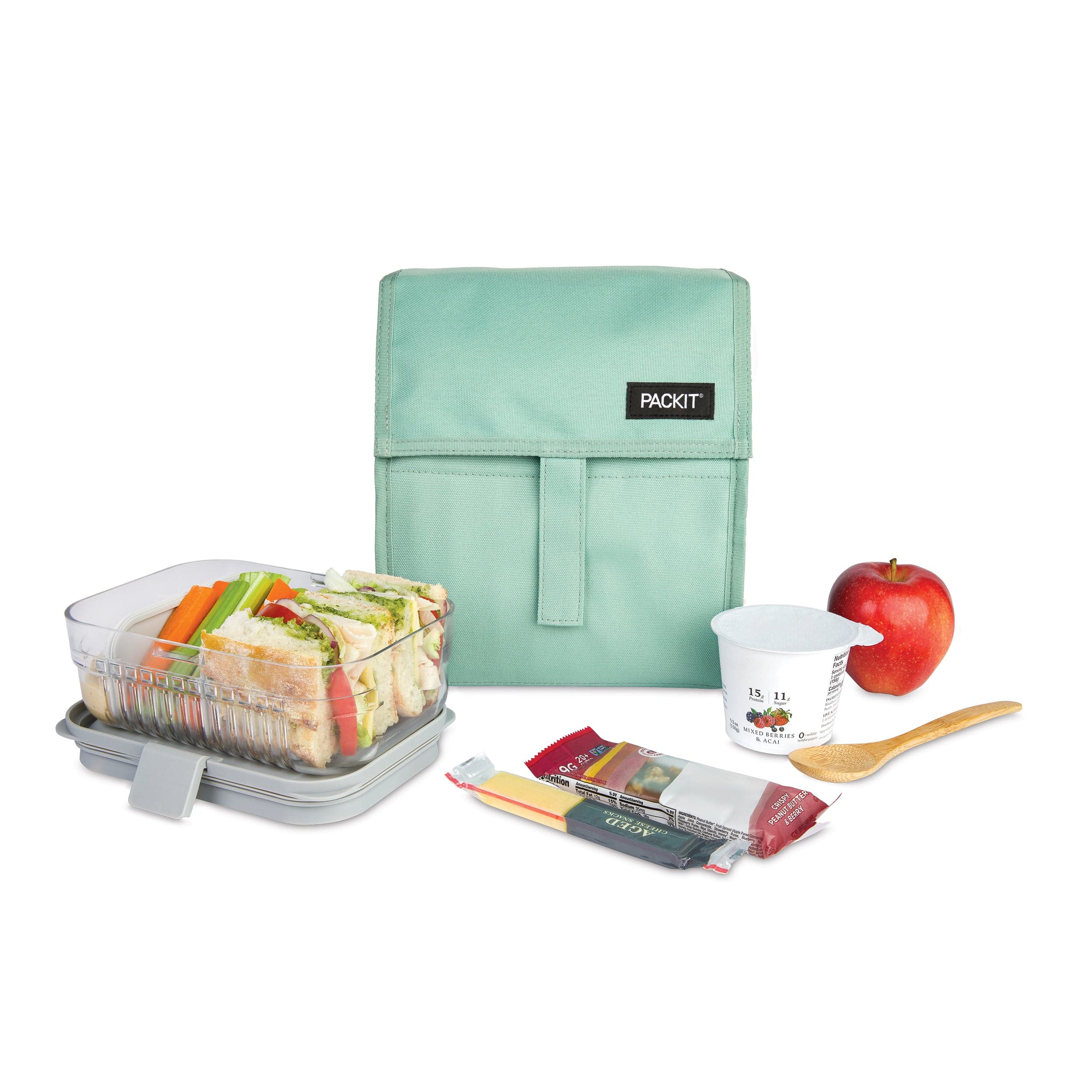 A lunch bag with a food container, drink, utensils, and snacks beside it