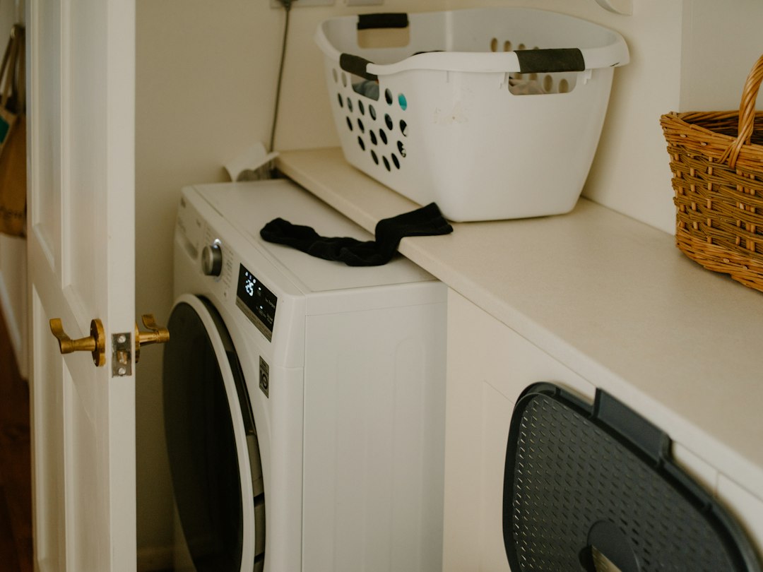 White washing machine with a laundry basket in a compact laundry space