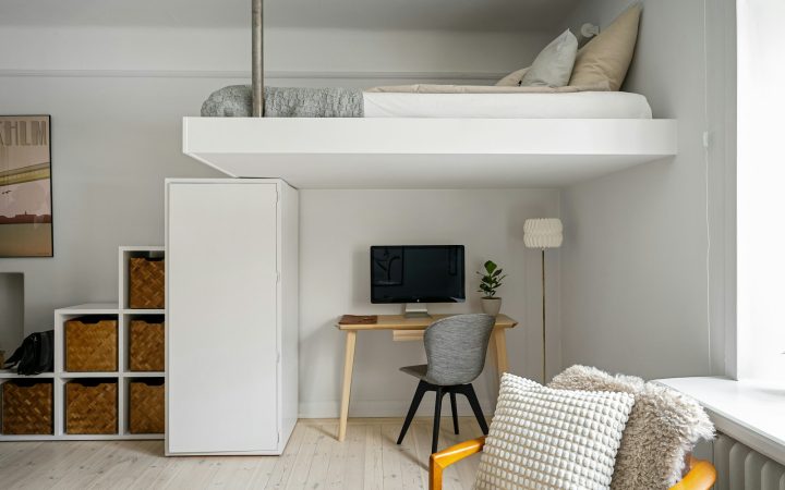 Compact room with loft bed and desk showing zoned use