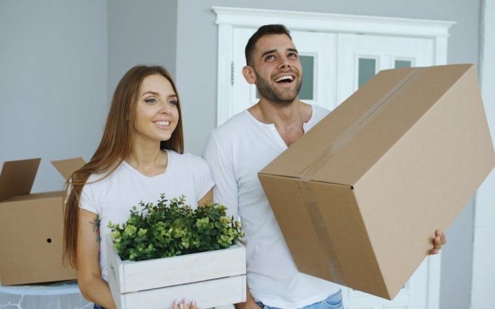 Couple standing in a new home surrounded by moving boxes