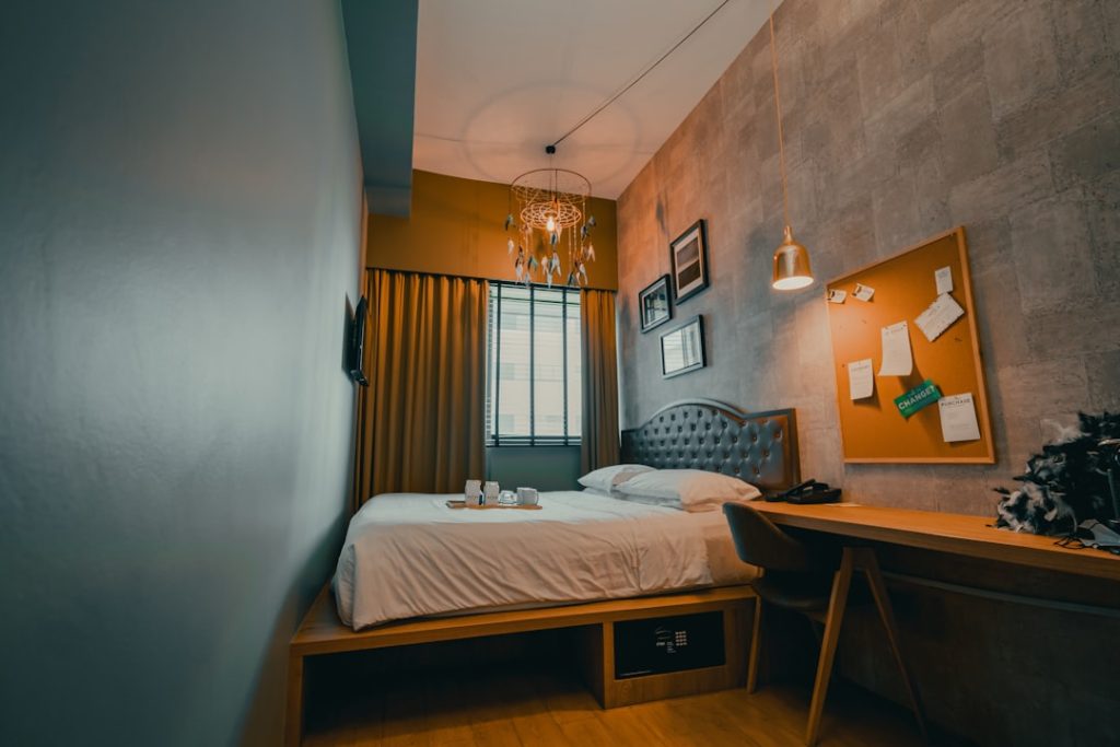 Tidy small bedroom with white bedding and limited visible clutter