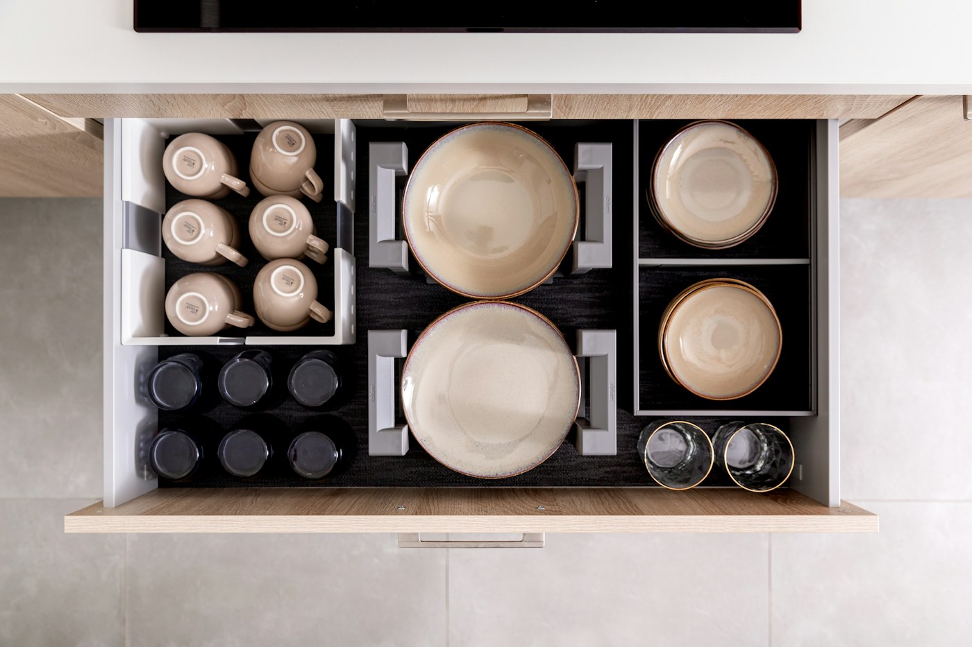 Organized kitchen drawer showing grouped household categories from above
