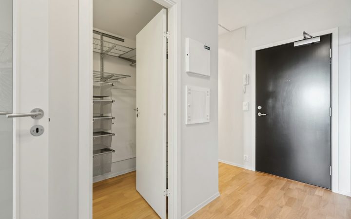 Small apartment room with open floor area and minimal built-in storage