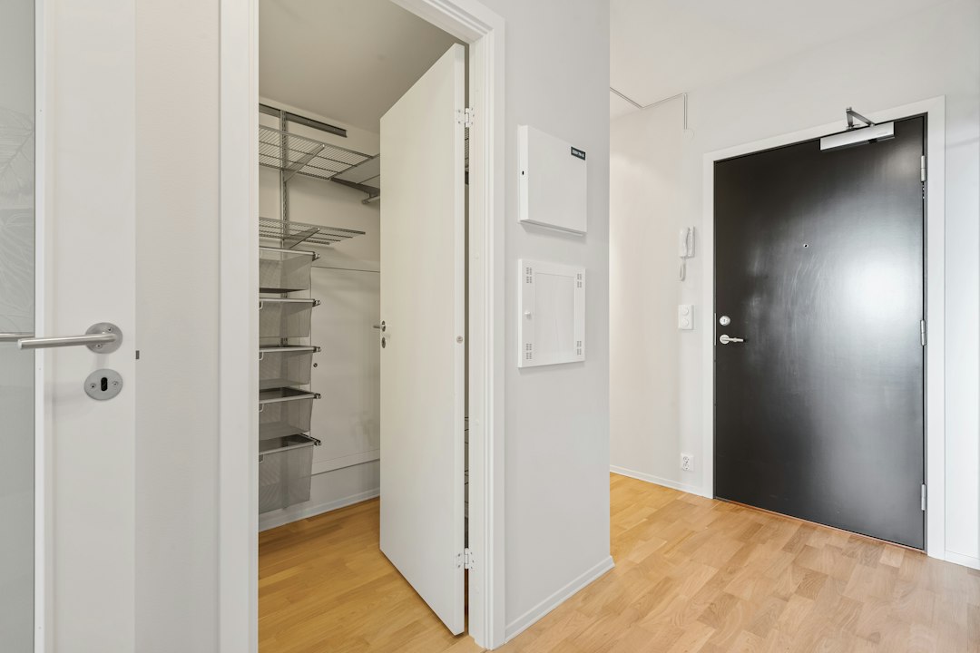 Small apartment room with open floor area and minimal built-in storage