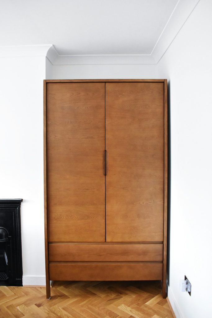 Small apartment entryway with a narrow bench and wall storage