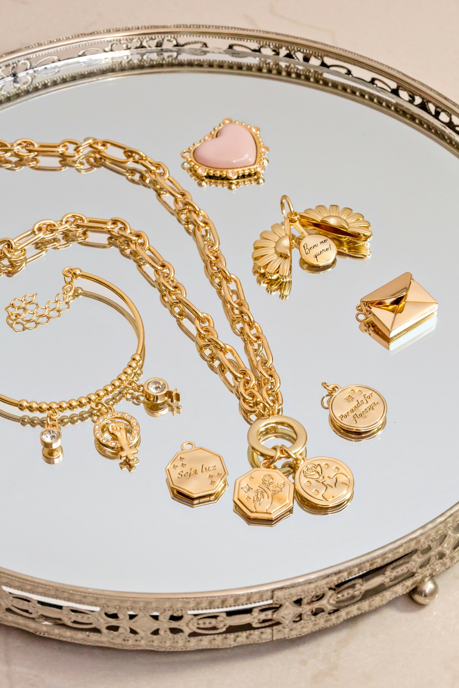 Gold jewelry spread across a silver-colored tray