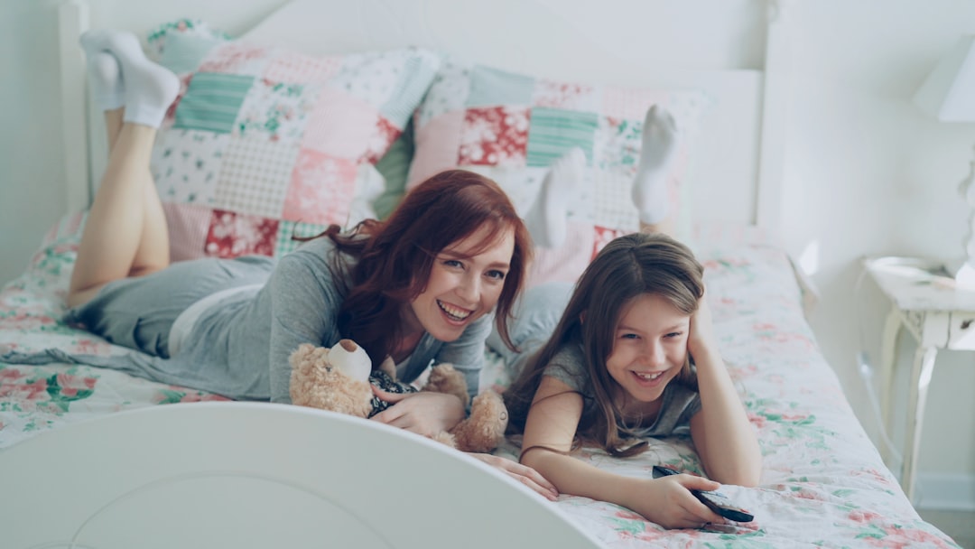 Parent and child relaxing on a bed in a cozy family bedroom