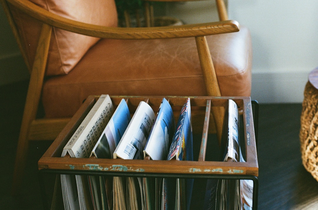 Compact magazine rack beside a chair creating a clear reading-material boundary