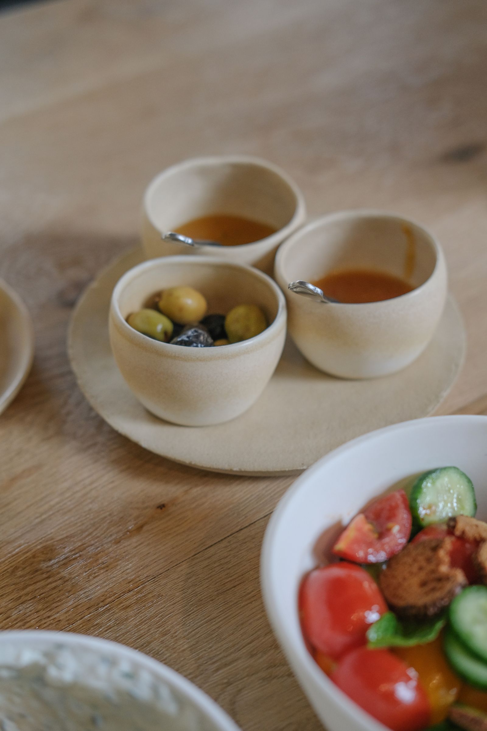 Salad and small bowls of accompaniments on a dining table
