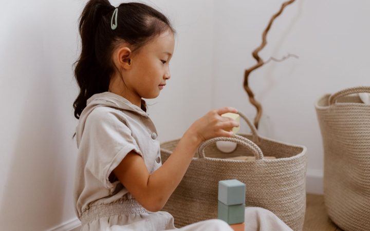 Young child organizing toys into a basket in a calm home setting