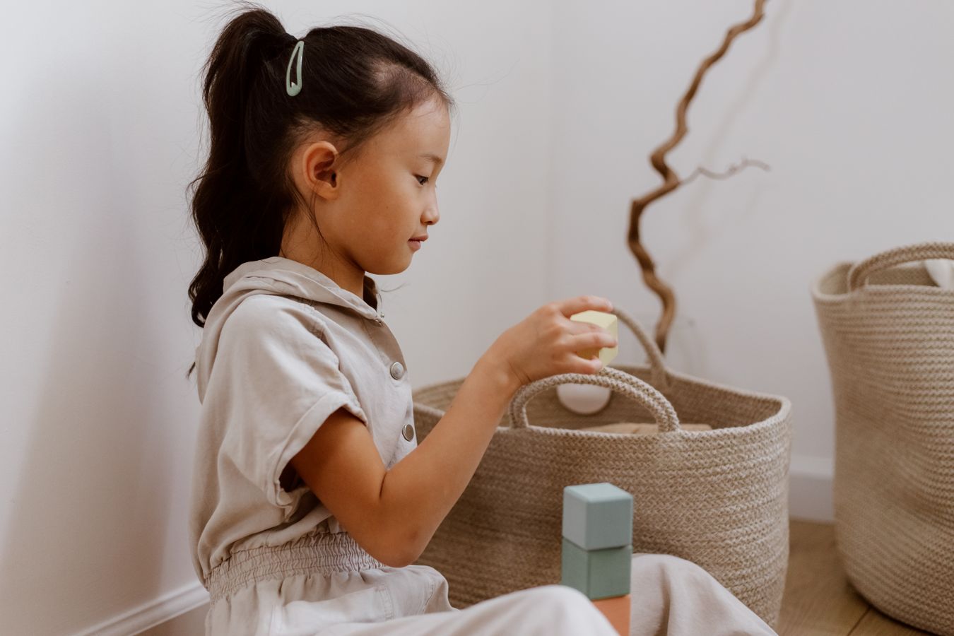 Young child organizing toys into a basket in a calm home setting