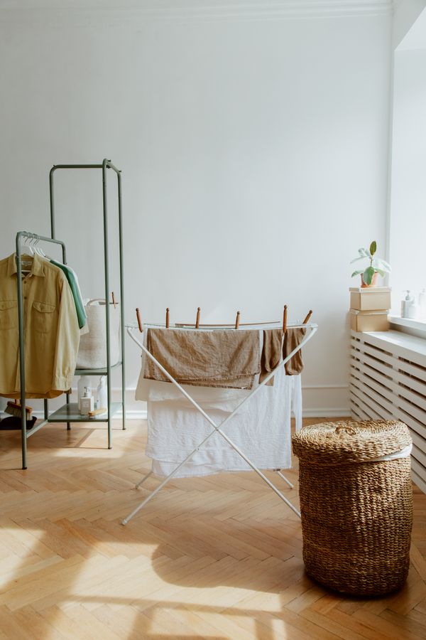 Small tidy laundry area with clothes drying and a woven laundry basket