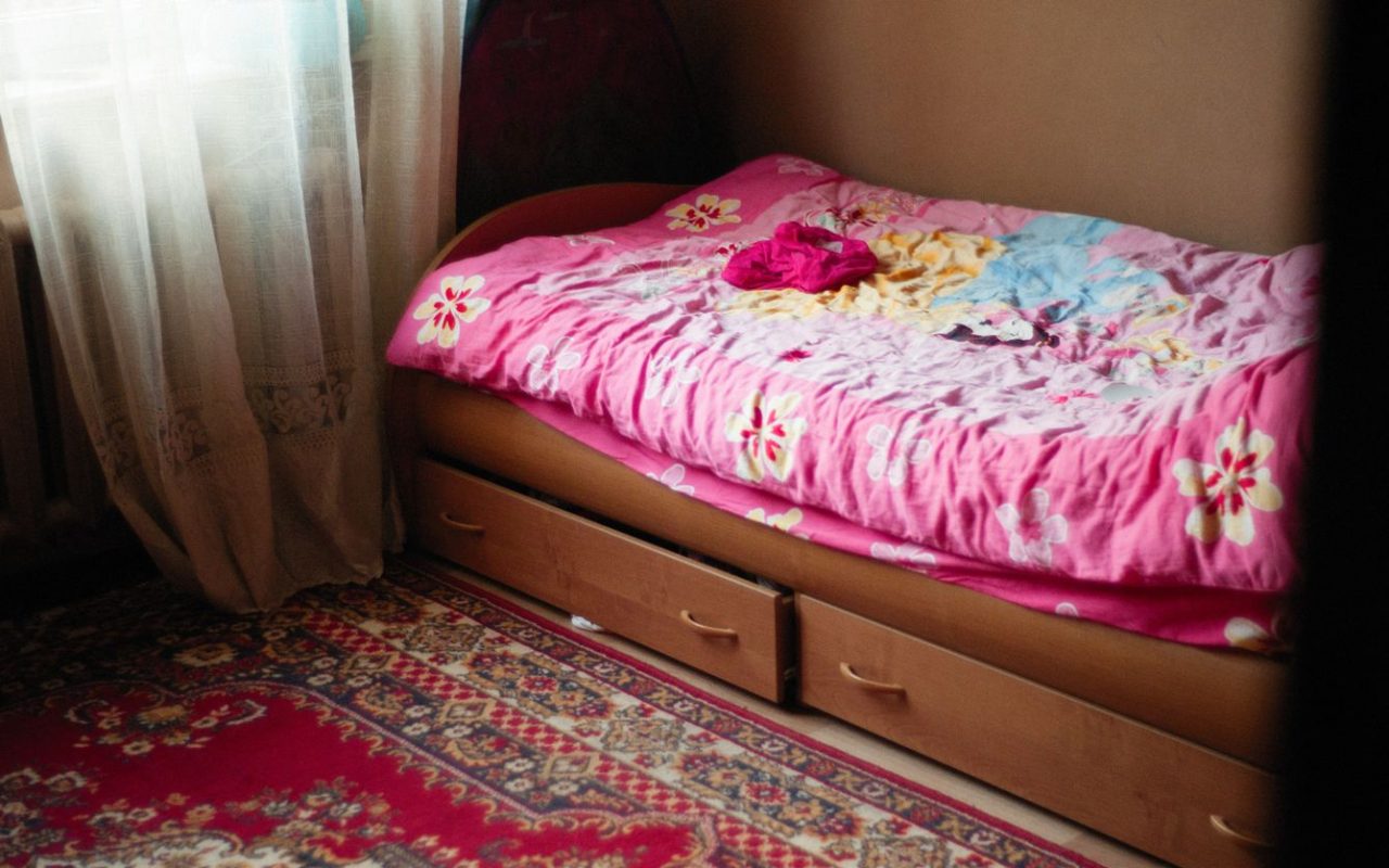 Small bedroom with drawers built under the bed, illustrating storage that uses existing furniture volume