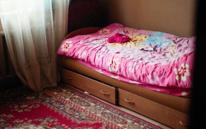 Small bedroom with drawers built under the bed, illustrating storage that uses existing furniture volume