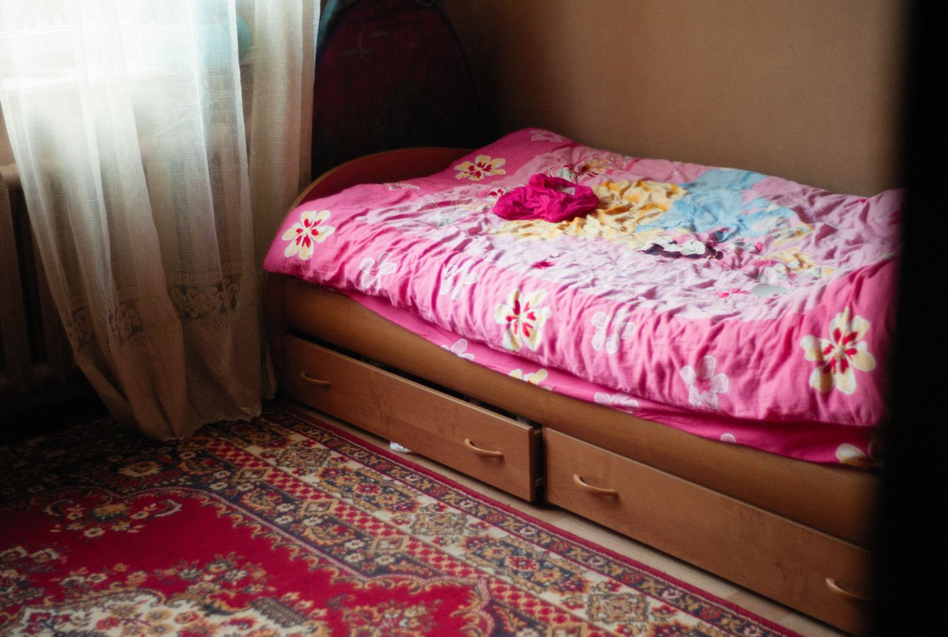 Small bedroom with drawers built under the bed, illustrating storage that uses existing furniture volume