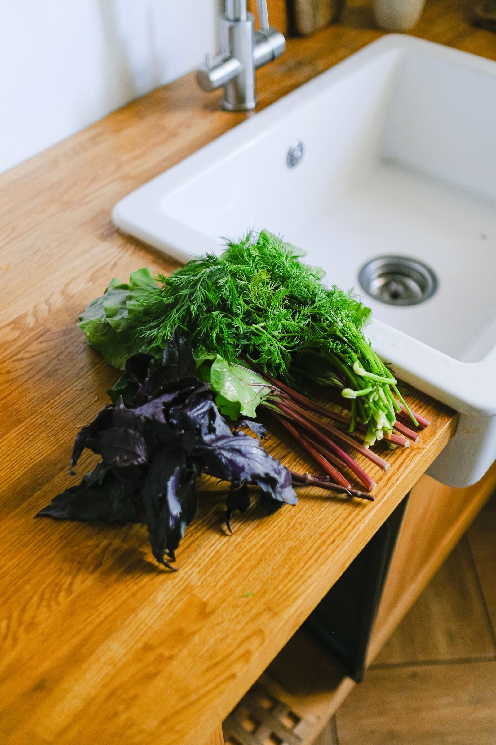 Fresh vegetables beside a kitchen sink