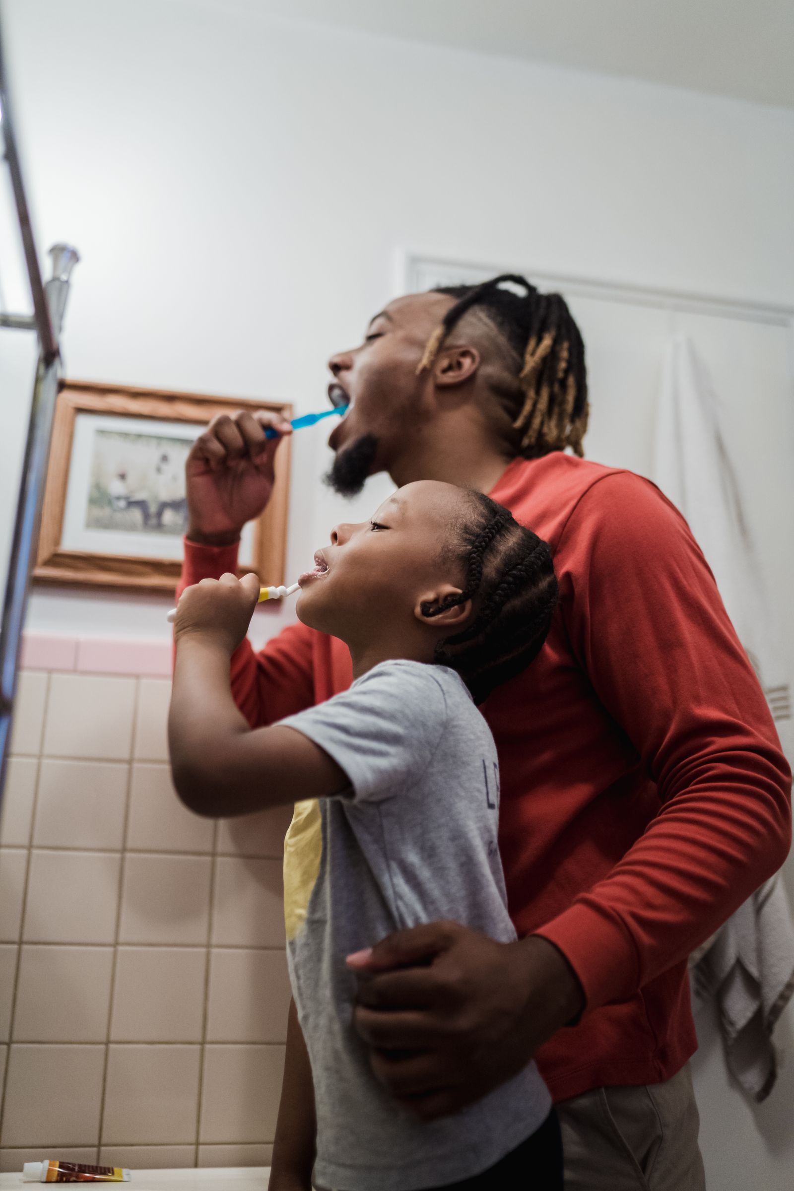 Father and daughter using a bathroom during the morning
