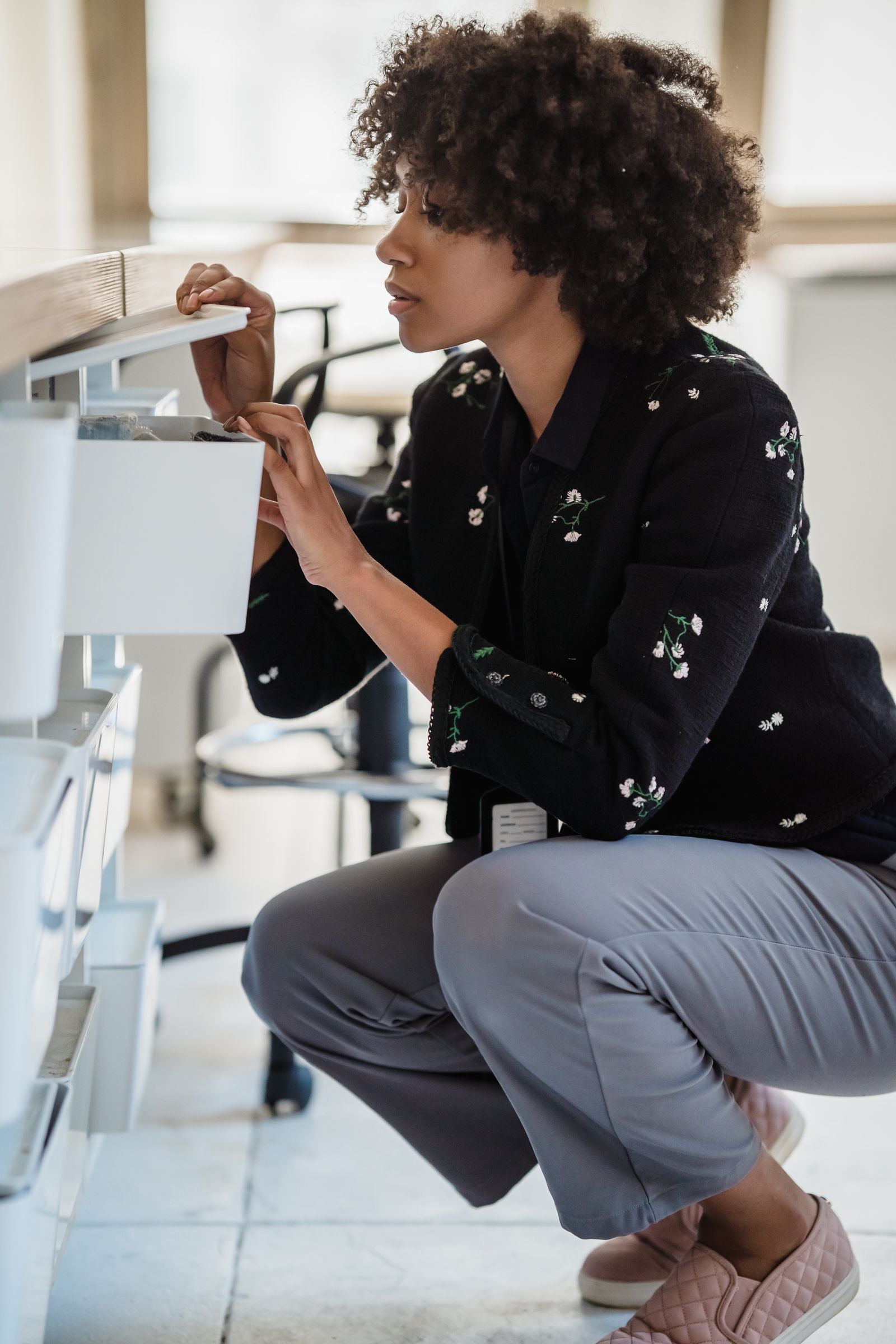 Woman organizing office supplies in a storage drawer