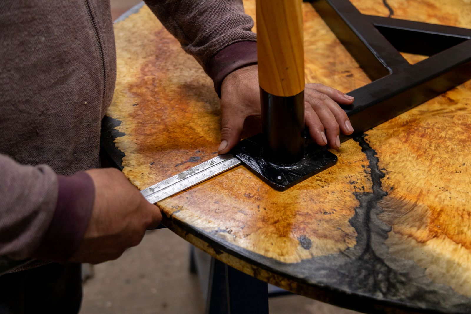 A person measuring the underside of an upholstered chair
