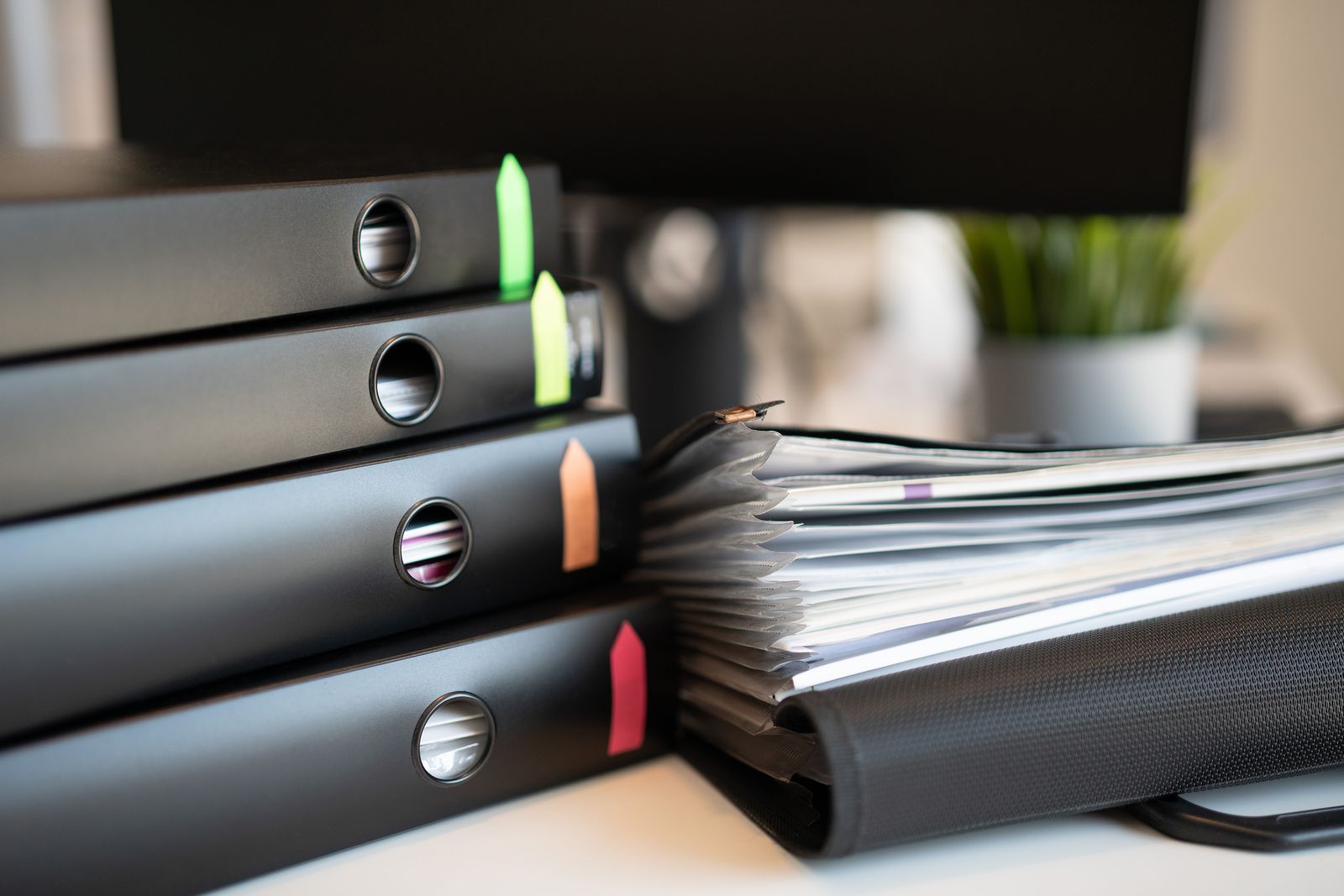 Stack of ring binders and documents on a desk