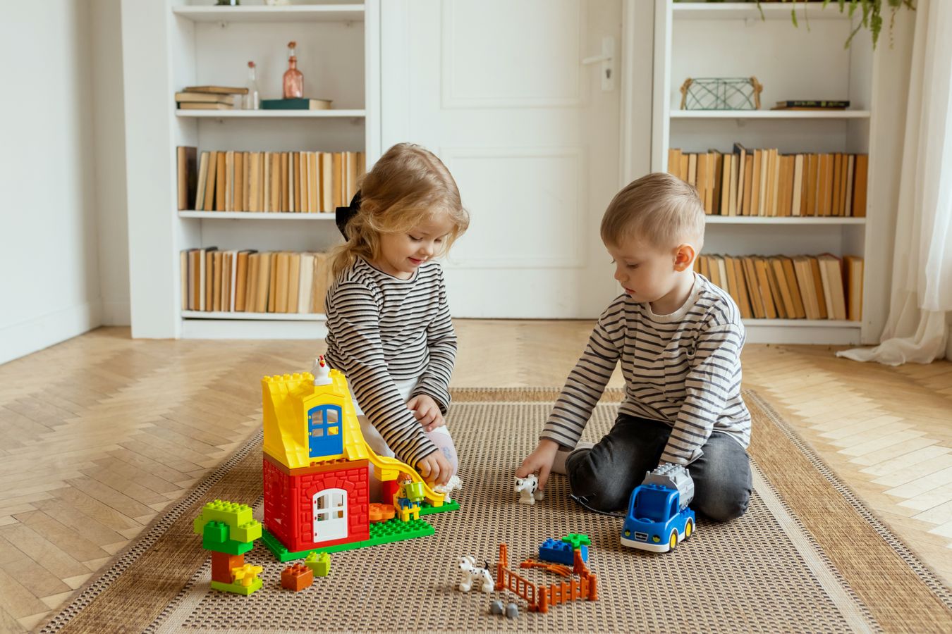 Children playing with toys in a contained living-room area with open floor space