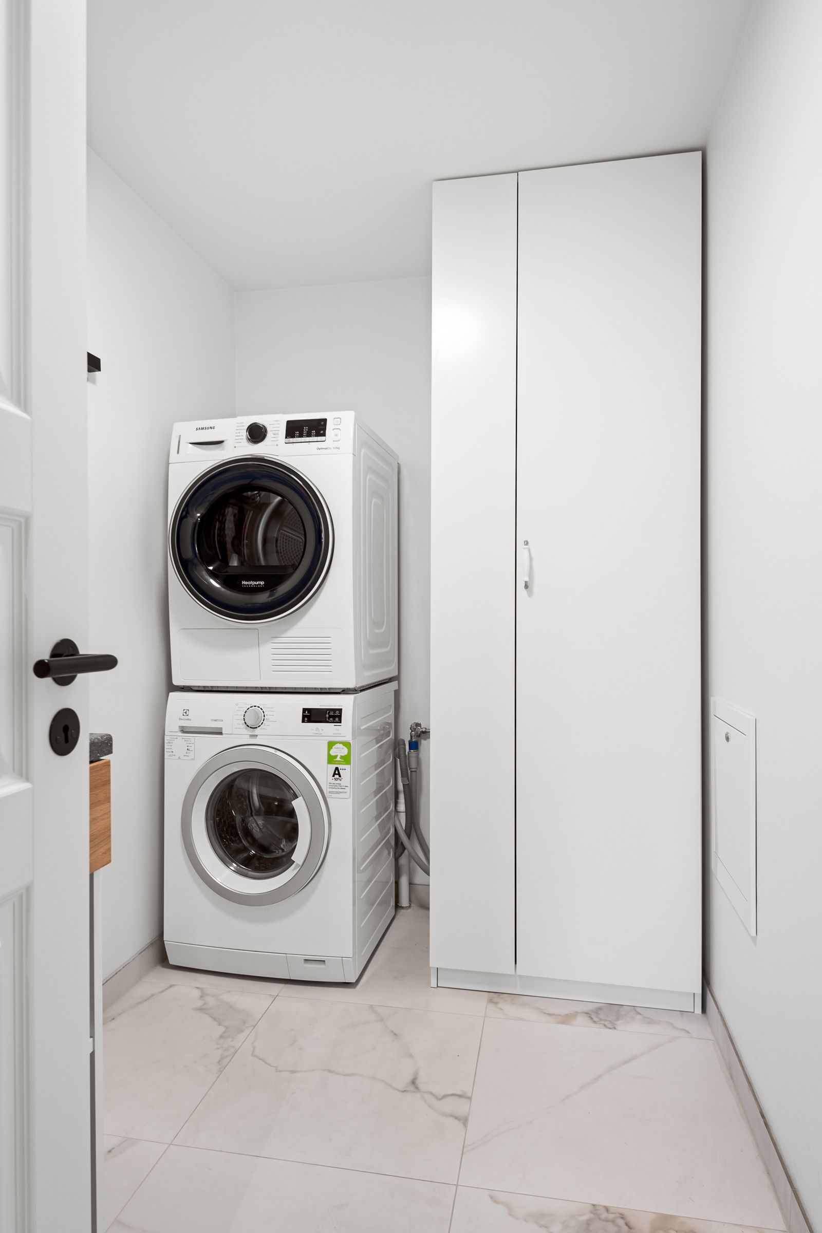 Neat laundry room with stacked washer and dryer
