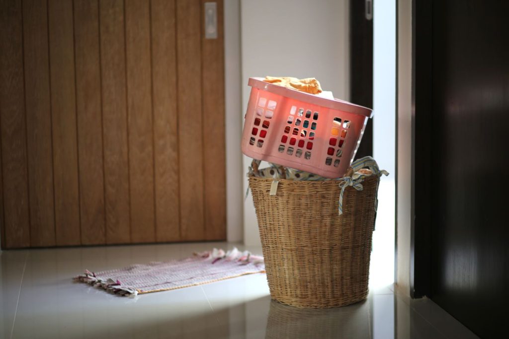 Two laundry baskets filled with clothing near a doorway, illustrating capacity and floor footprint