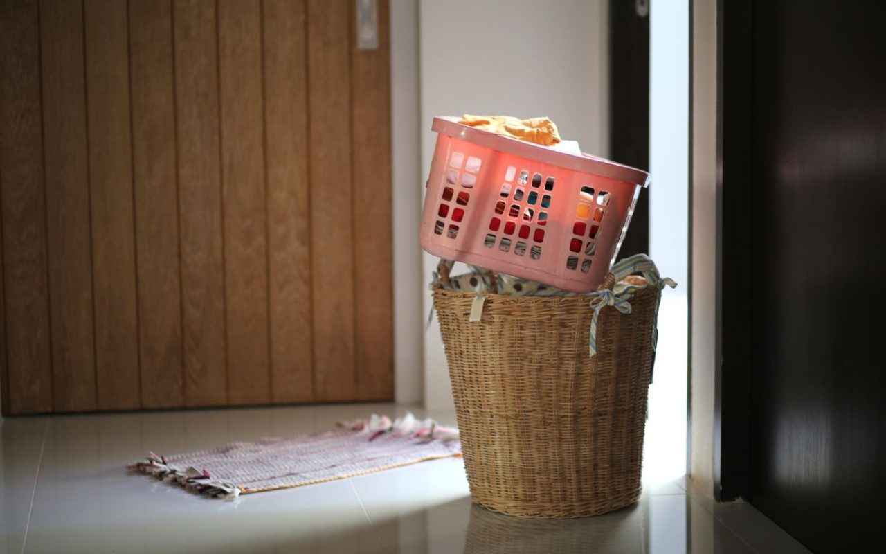 Two laundry baskets filled with clothing near a doorway, illustrating capacity and floor footprint
